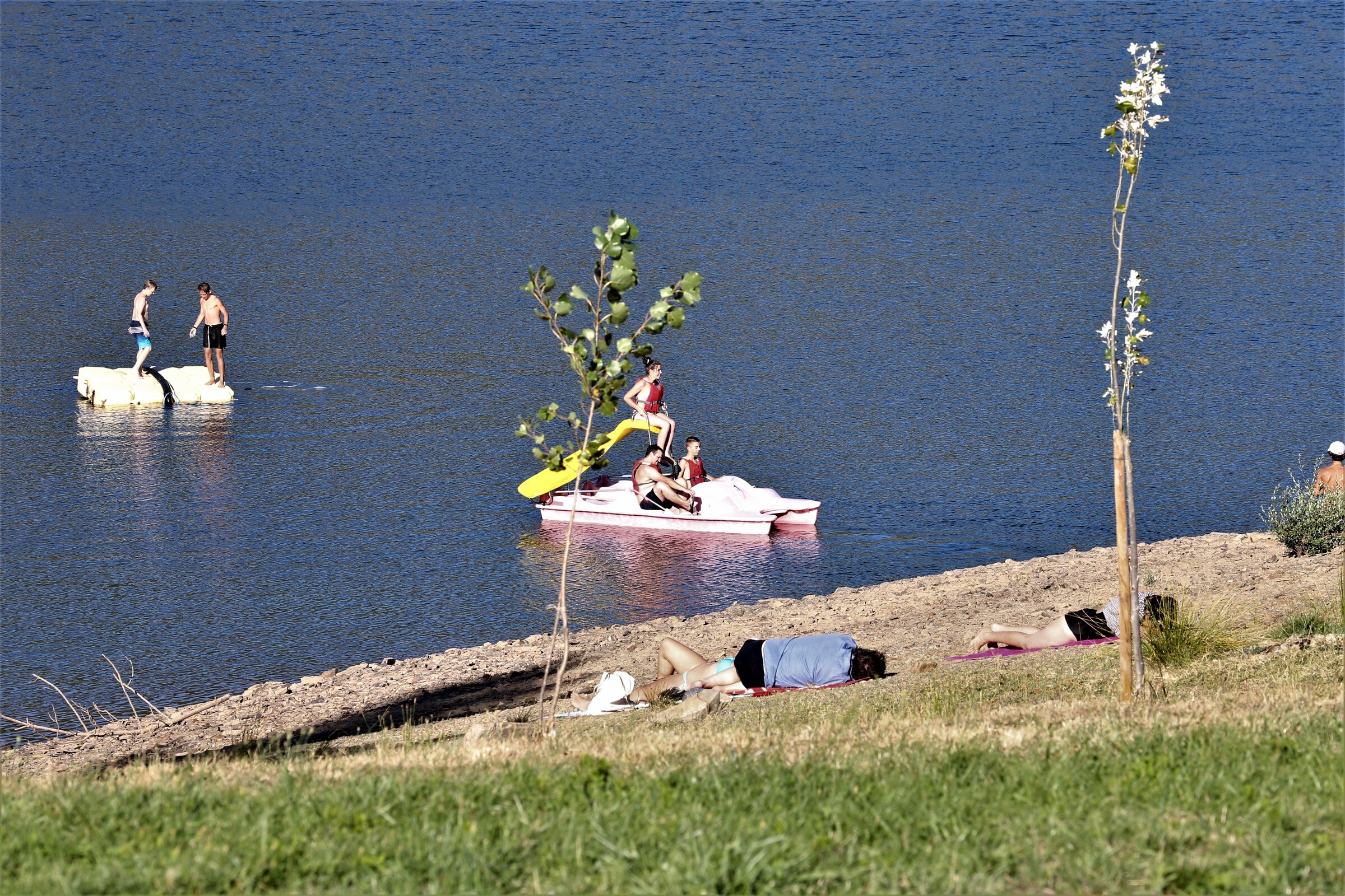 pessoas em pesqueno barco na margem do rio